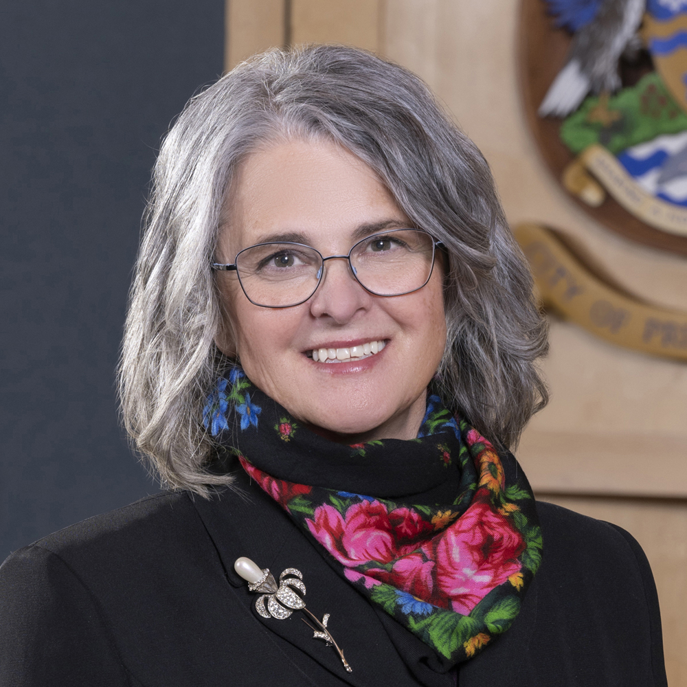 Headshot of Councillor Trudy Klassen in council chambers, with City of Prince George crest in background.