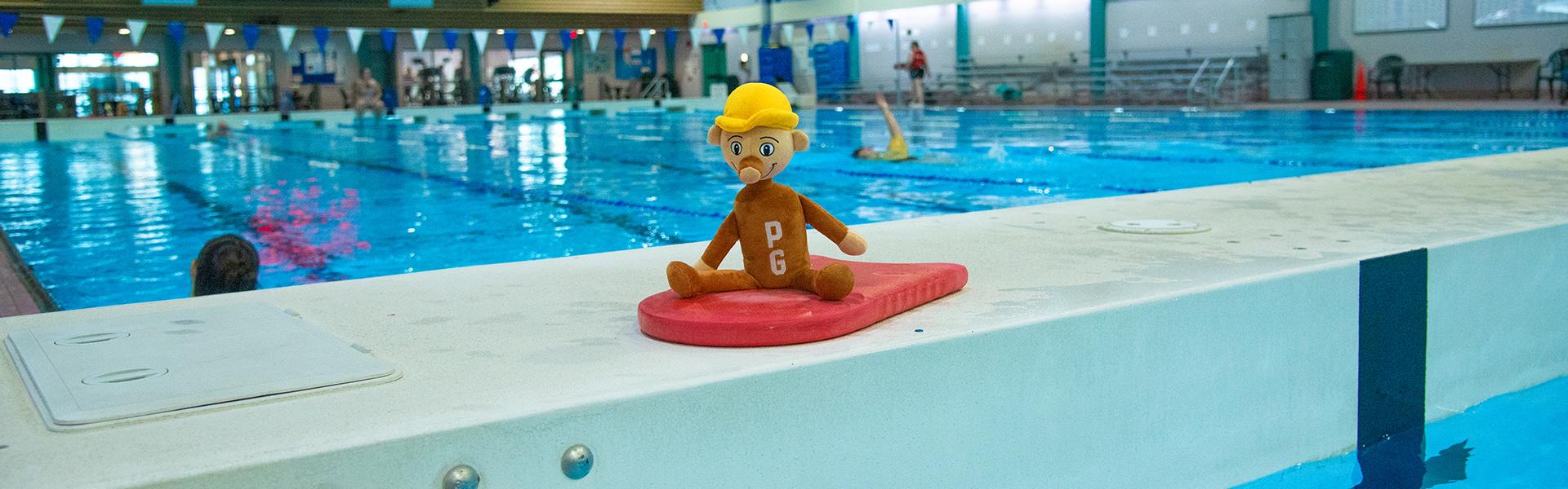 Stuffed toy of Mr PG resting on a pool floatation toy at the Prince George Aquatic Centre