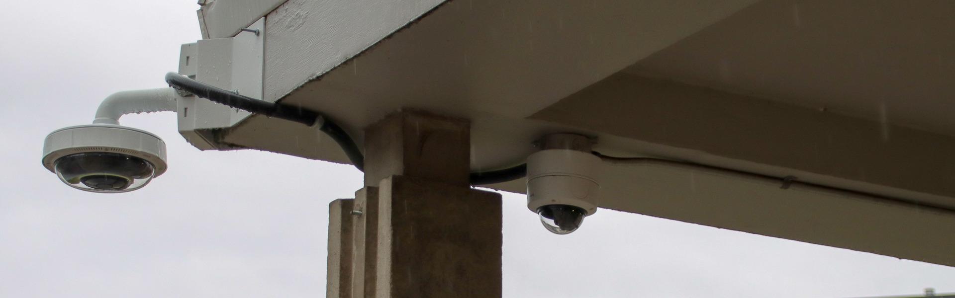 An outdoor security camera mounted to the corner of a building