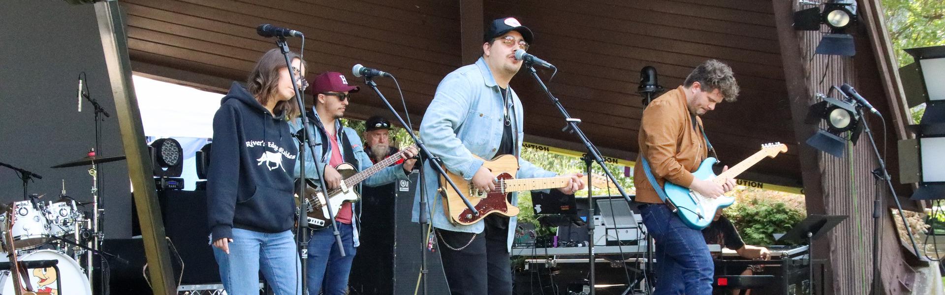 A band performing on stage at Lheidli T'enneh Memorial Park