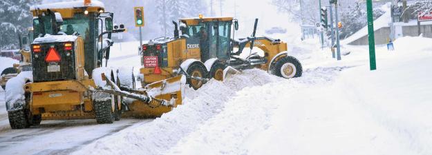 Snow plows clearing snow on a city street