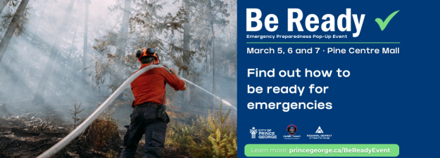 A wildfire fighter using a hose to spray a fire in the forest