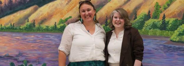 Artists Kim Hayhurst and Erin Stagg smile in front of their mural at the Civic Centre 