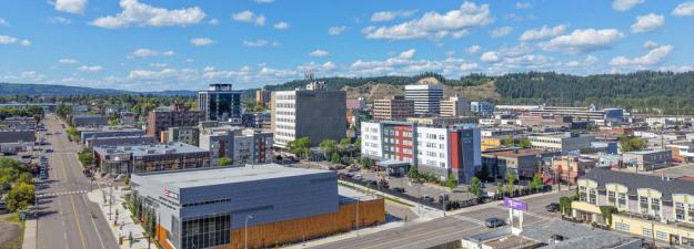 Aerial photo of downtown Prince George looking towards the Canfor Leisure Pool and the cutbanks on a sunny day with a blue sky