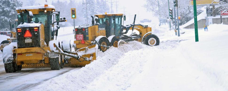Snow plows clearing snow on a city street