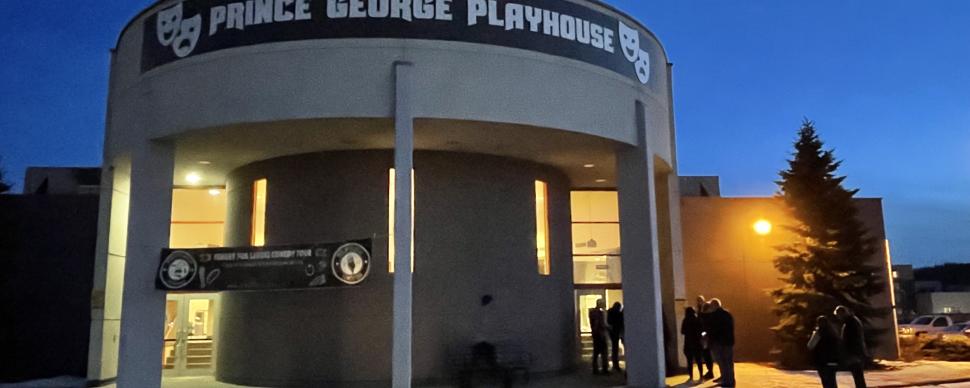 outside of the prince george playhouse at night with a crowd of 5 people gathered