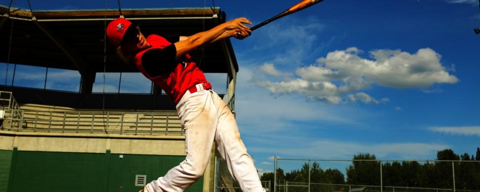 Baseball player swinging bat at a civic ball diamond