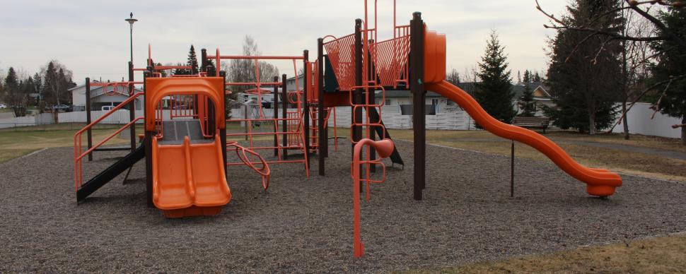 Orange coloured playground, with multiple slides, poles, and climbing areas.