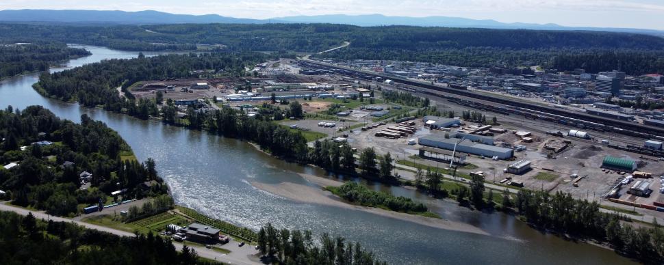 Aerial view of Prince George from the cutbanks. Pulp Mill Road and Nechako river in foreground, with River Road, the railway tracks, and downtown in the background.