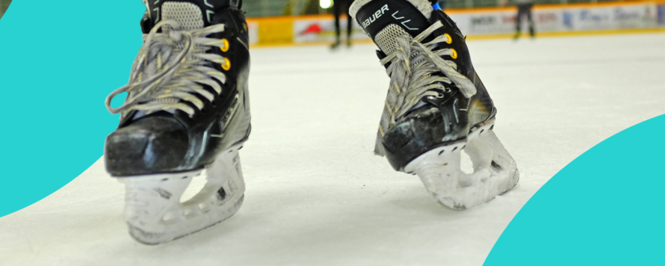 A closeup of hockey skates on ice in an arena, with blue graphic swoop on the left and right sides of the image