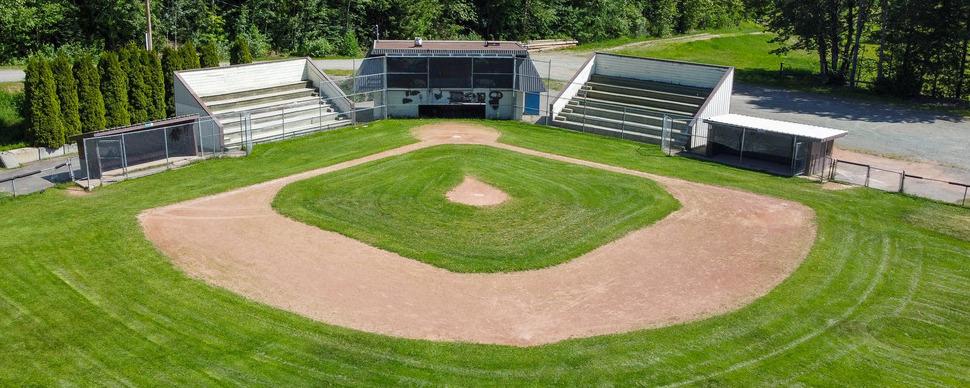 aerial view of baseball diamond facing home plate, with dugouts and bleachers visible