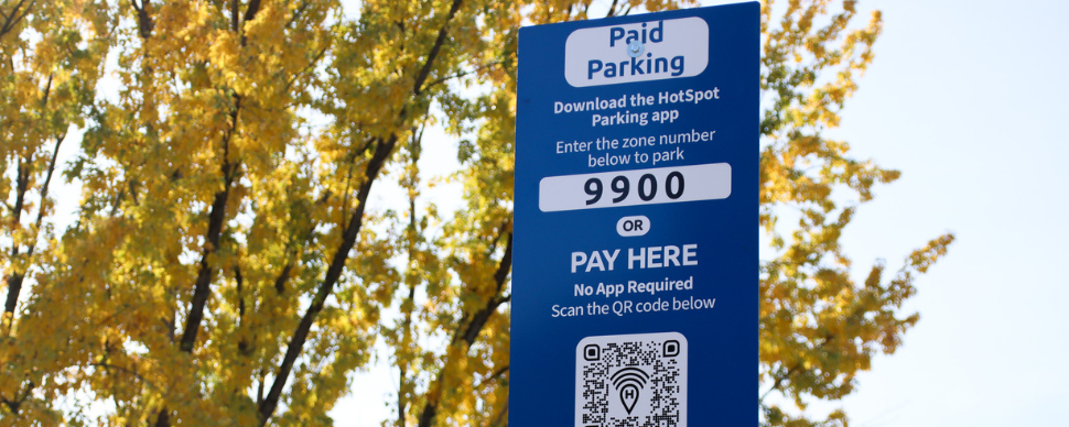 A parking sign in front of a tree