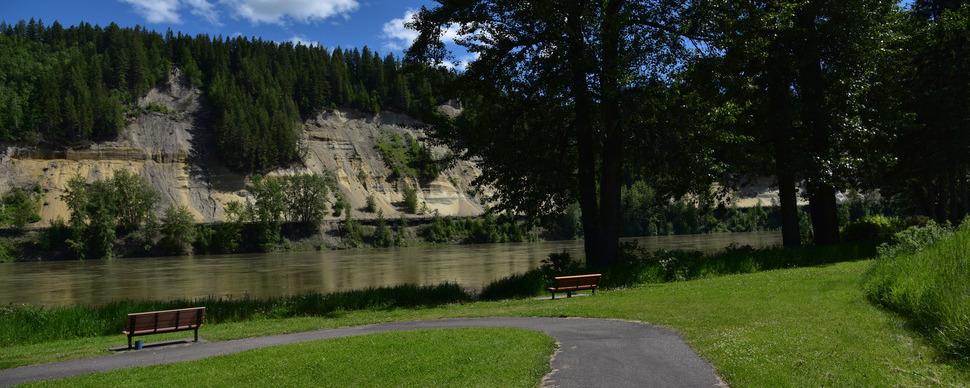Riverside park with paved path and benches