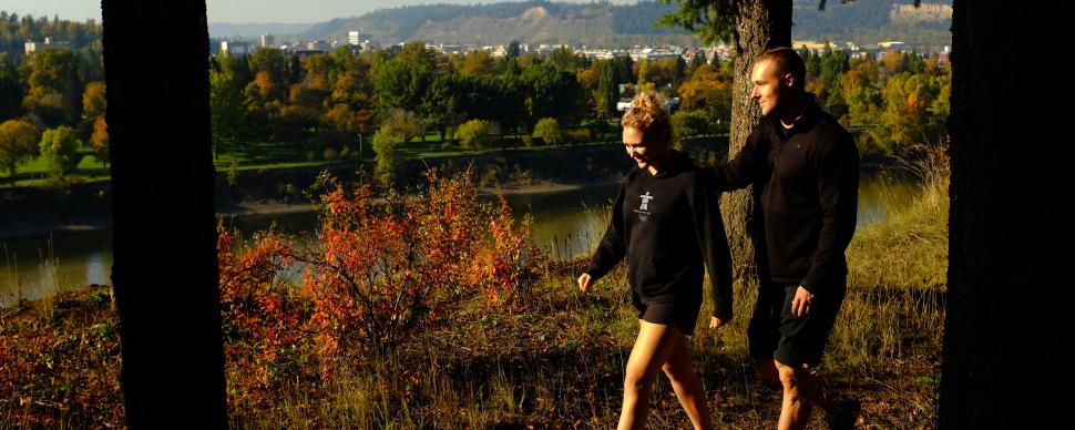 A couple walking along the trail at the park on a fall day. 