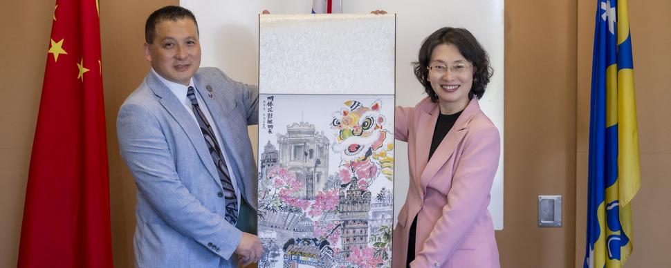 Mayor Simon Yu and Mayor Wu Xiaohui smile and hold artwork from China as part of the delegation from Jiangmen's visit