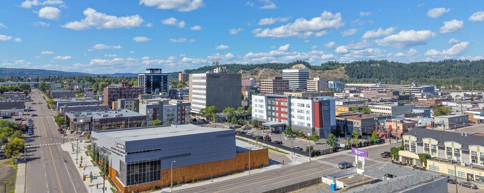 Aerial photo of downtown Prince George looking towards the Canfor Leisure Pool and the cutbanks on a sunny day with a blue sky