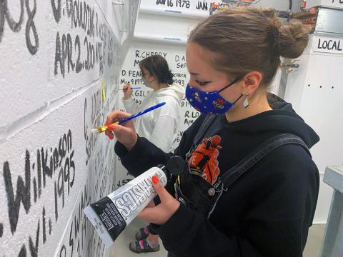 Gabriella Vis (foreground) and Brenna Harasym do a few touch-ups on the hose tower wall at the City of Prince George's new Fire Hall #1